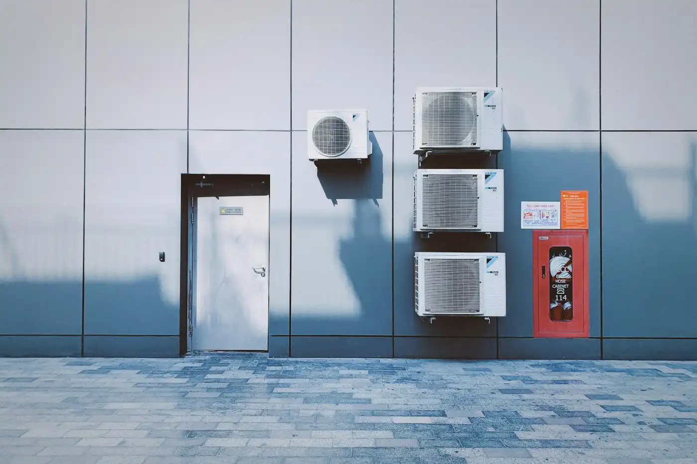 Outdoor units on a grey panelled wall