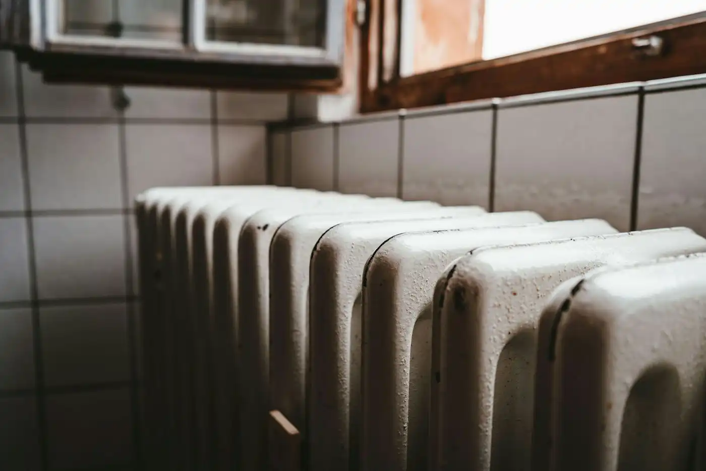 White radiator beside a wooden window