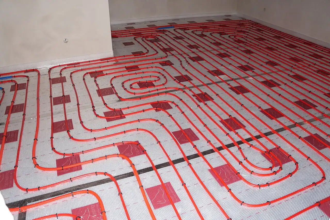 Red underfloor heating pipes laid across a room